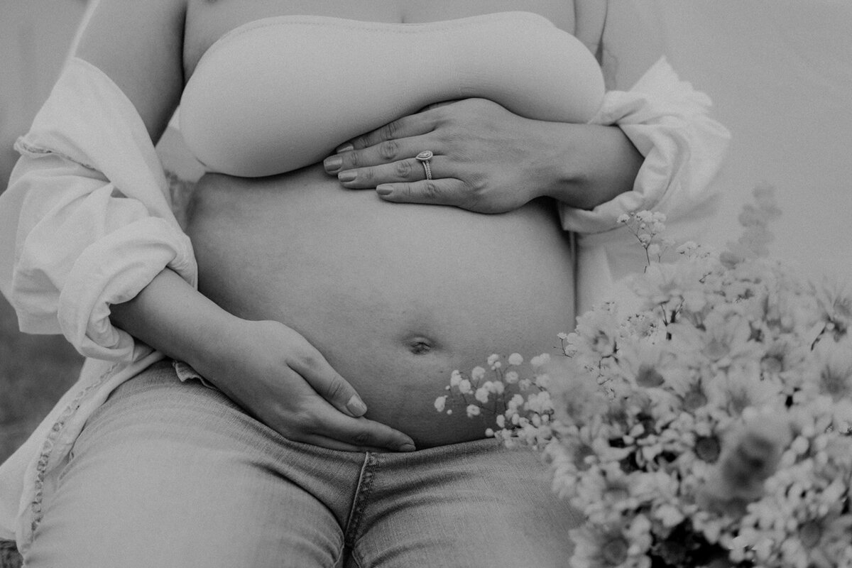 Close up of flowers near a pregnant belly