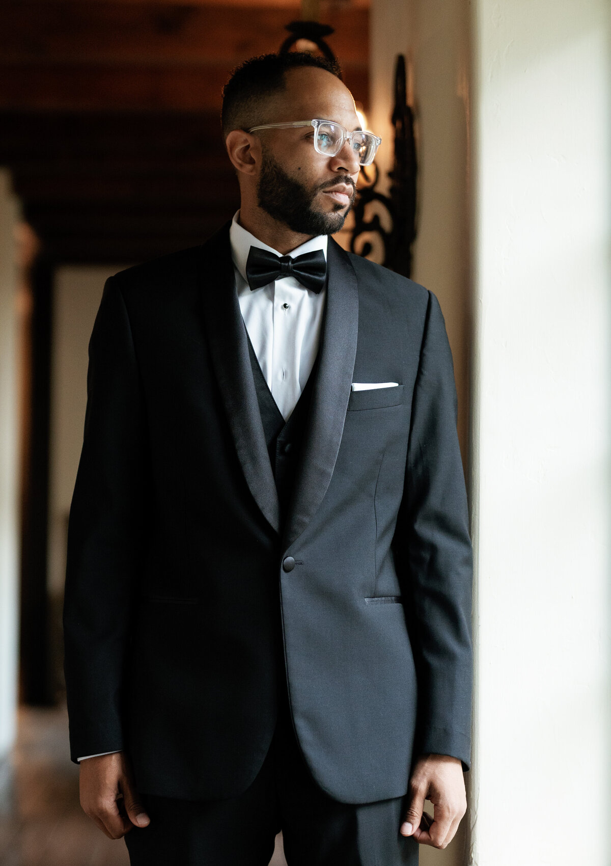 Groom in a classic black tuxedo posing indoors before his fall wedding at Castle Ladyhawke in Tuckasegee, NC.
