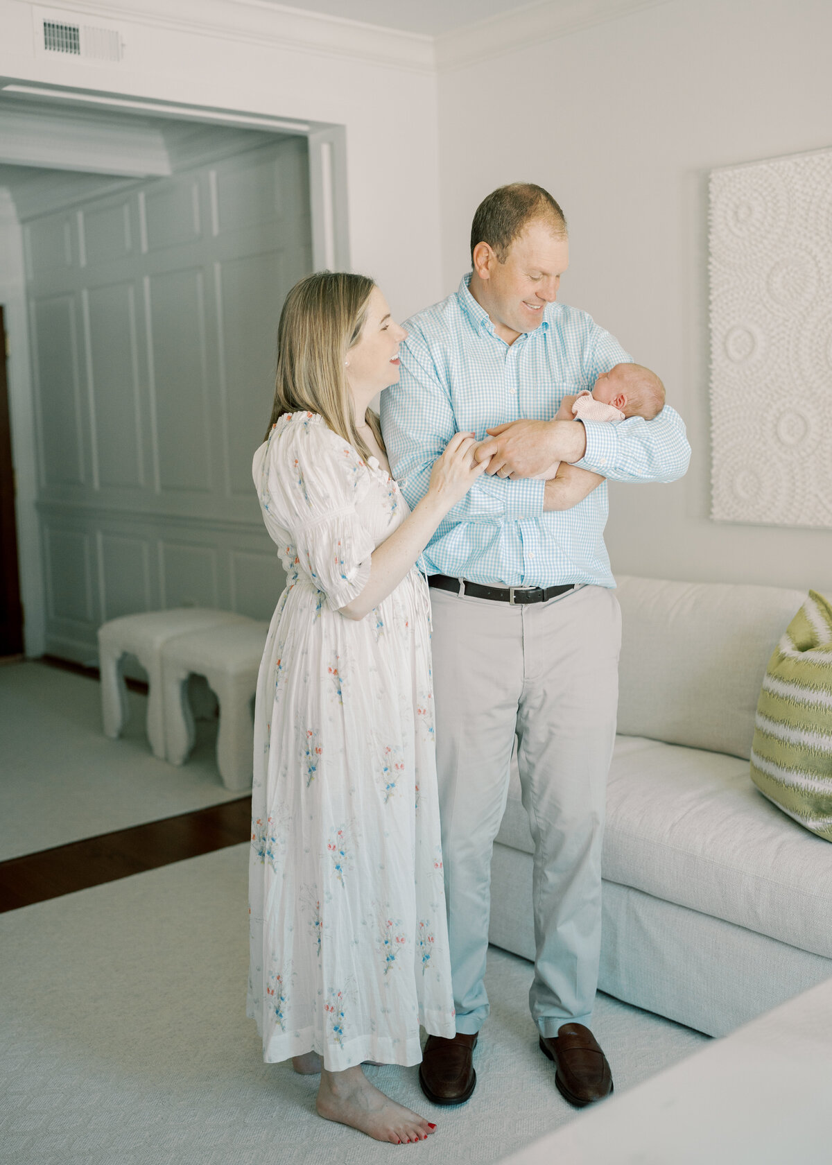 mom holding dads arm and dad holding newborn baby in Williamsburg Va
