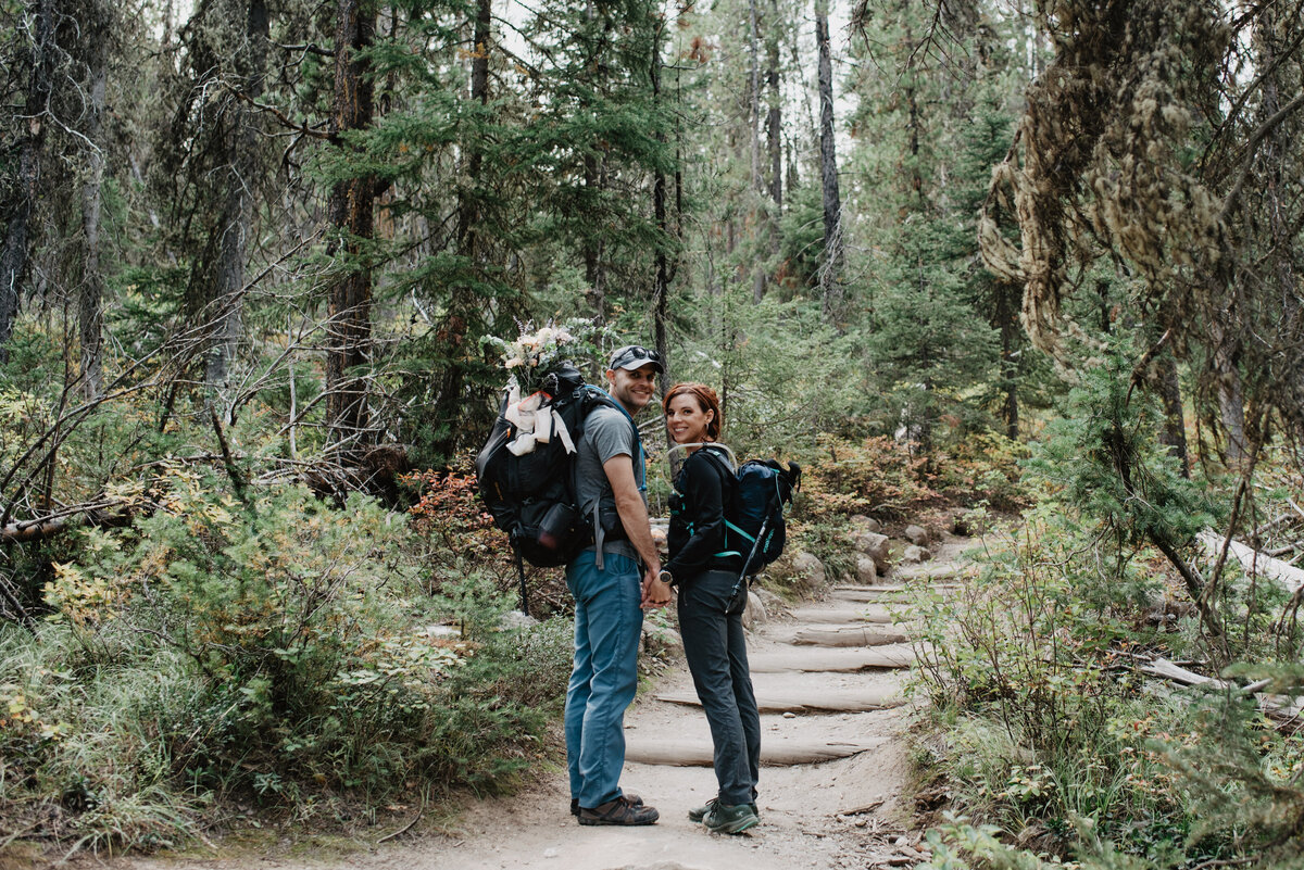 Jackson Hole photographers capture couple holding hands and looking around