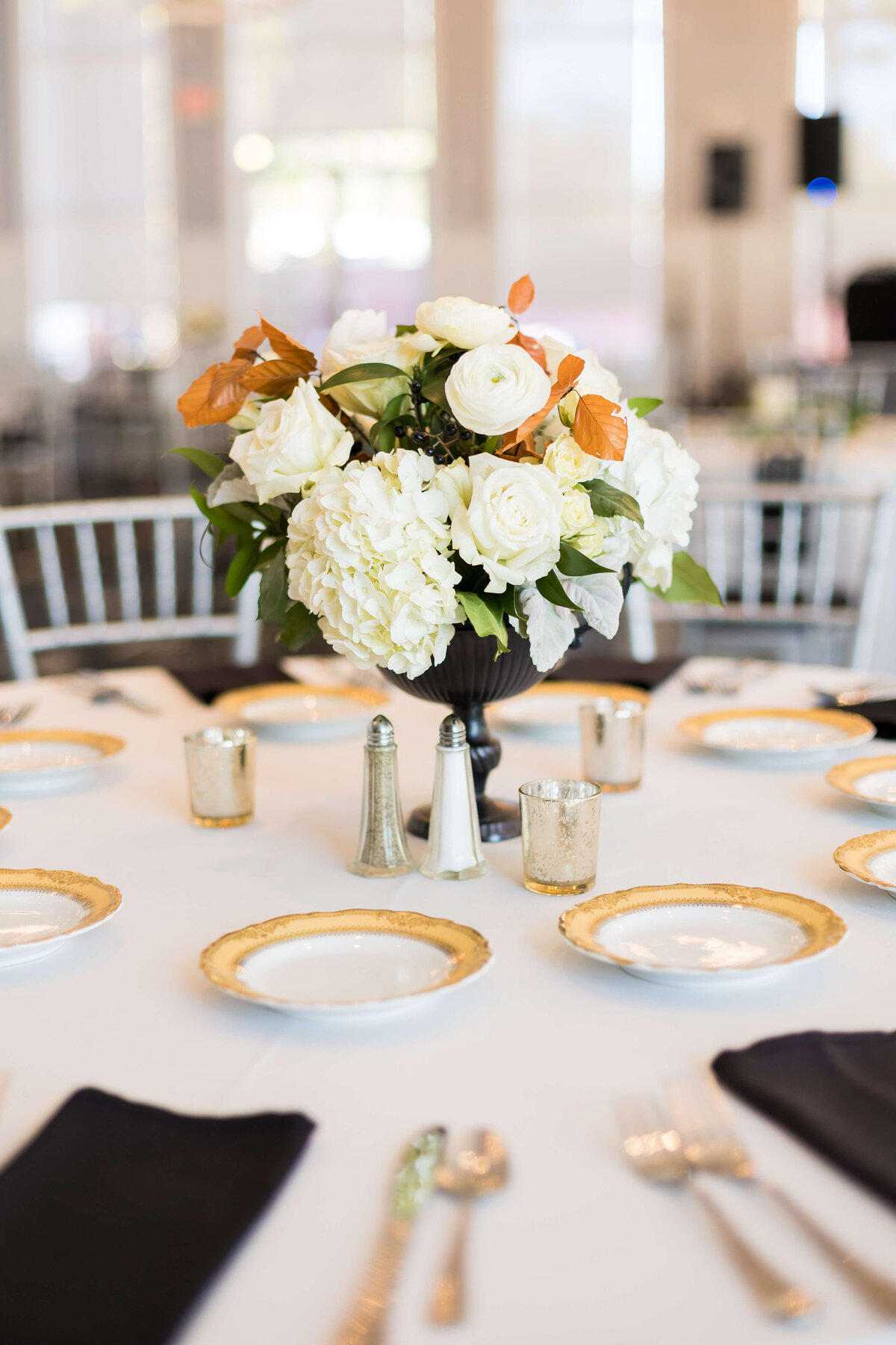 wedding florals centerpieces on round table with black napkins