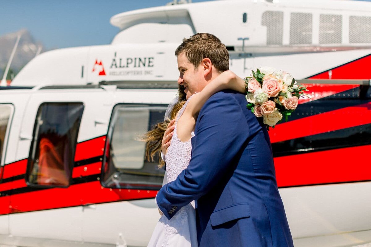 Bride-and-groom-hugging-after-their-first-look-in-Canmore-Alpine-Helicopter-pad