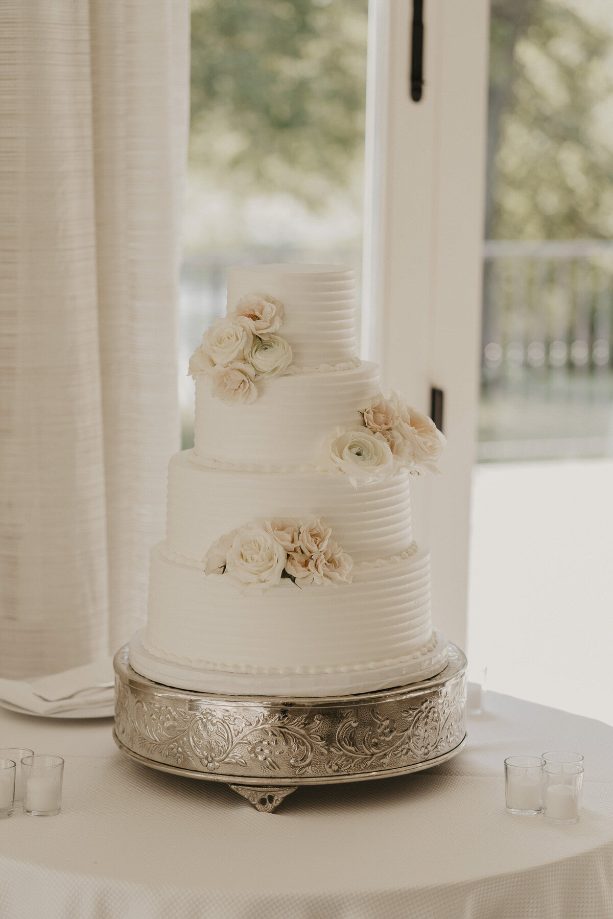 White wedding cake with pale blush flowers
