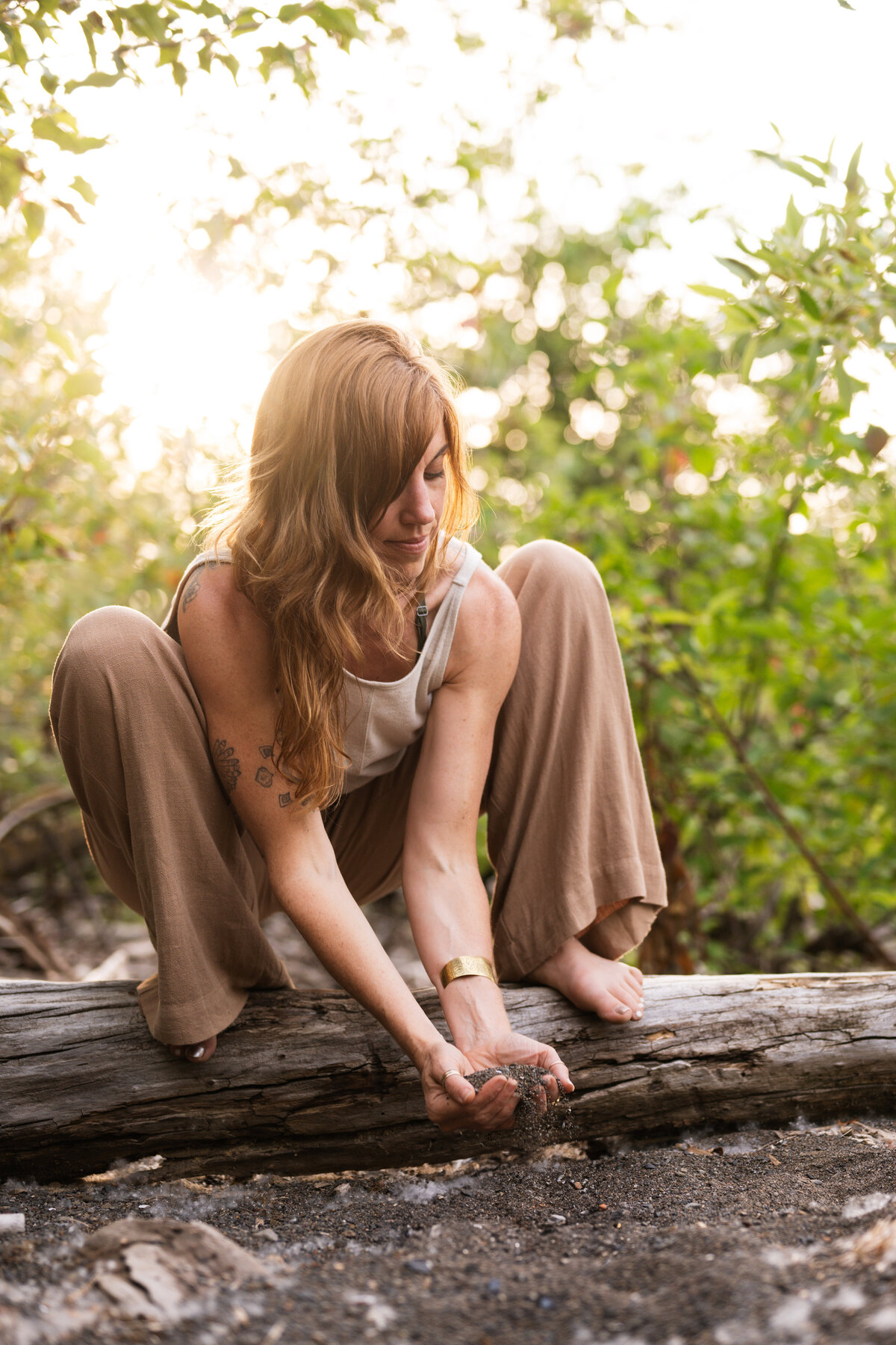 yoga teacher on a log holding the earth in her hands