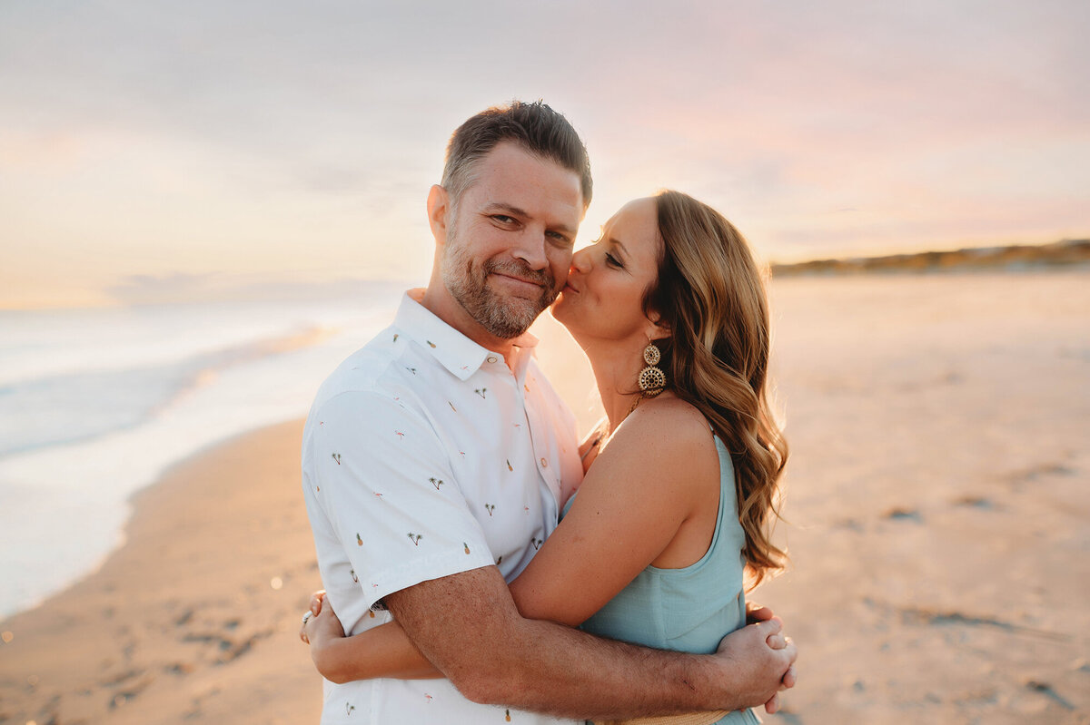 Wife kisses her husband during Family Pictures in Isle of Palms, South Carolina.