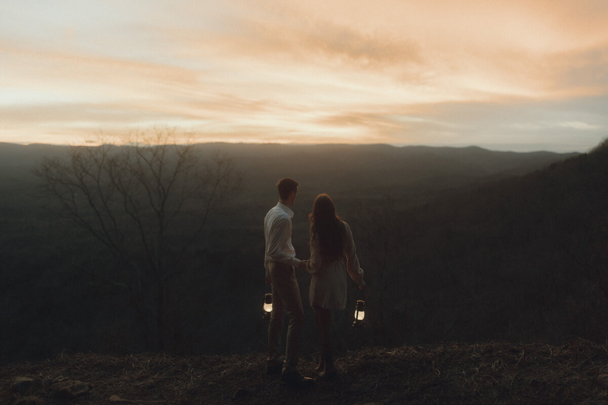 man and women embrace on mountain at golden hour