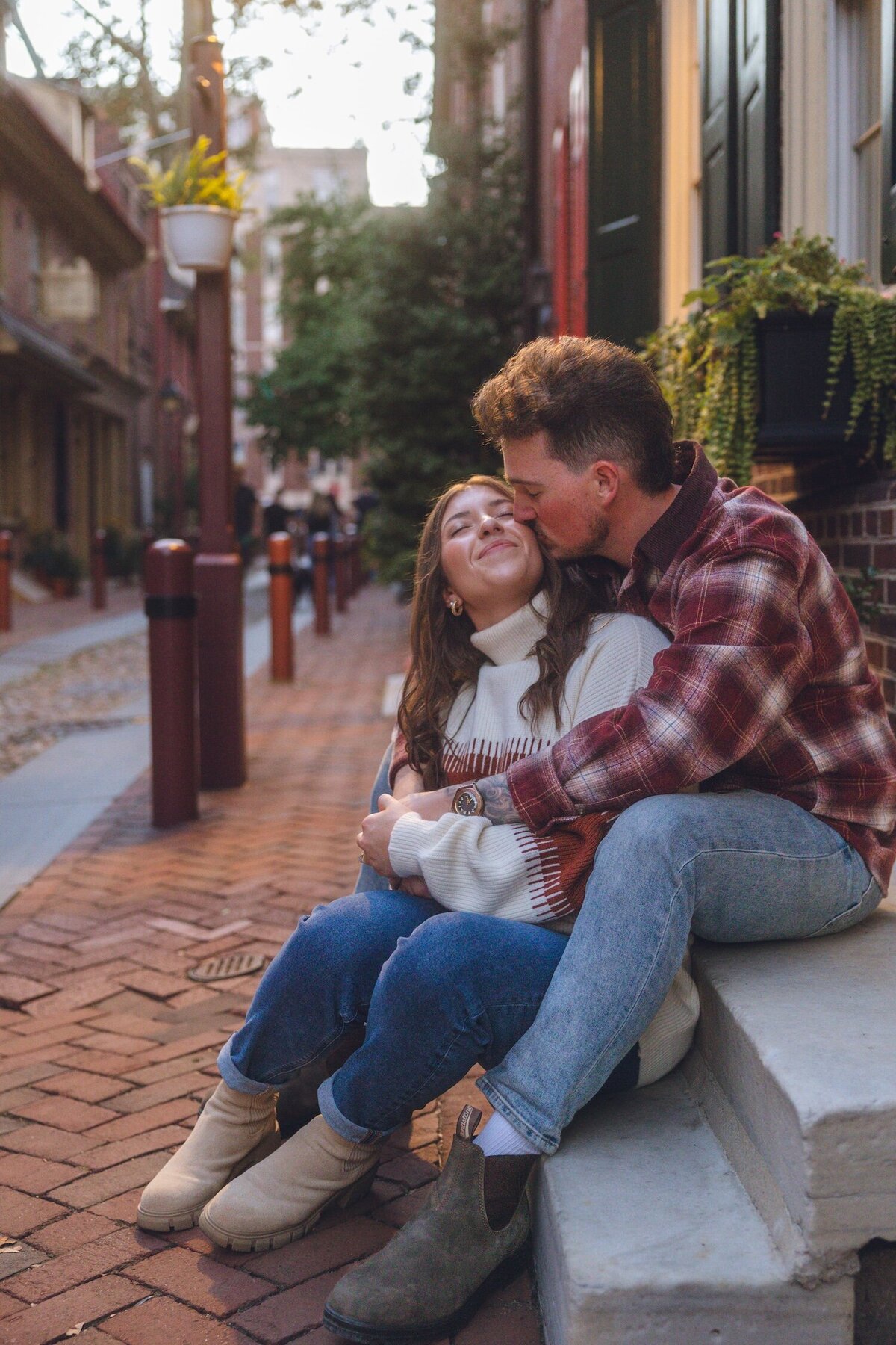 Sweet forehead kiss outside classic brick townhomes.