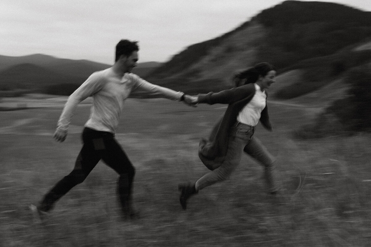 Modern motion blurred image of couple running holding hands, captured by Tim & Court Photo and Film, joyful and adventurous wedding photographer and videographer in Calgary, Alberta. Featured on the Bronte Bride Vendor Guide.