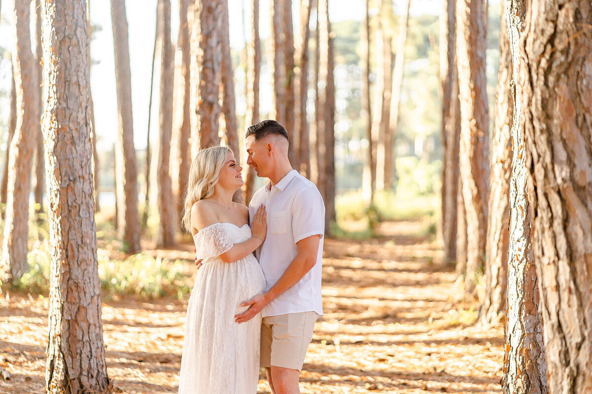Couple having maternity session in pizzey park pine forest in Gold Coast with Hikari