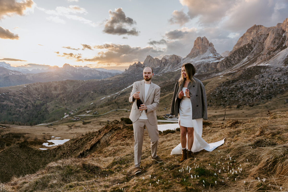 romantic couple drinking wine during twilight elopement in Dolomites