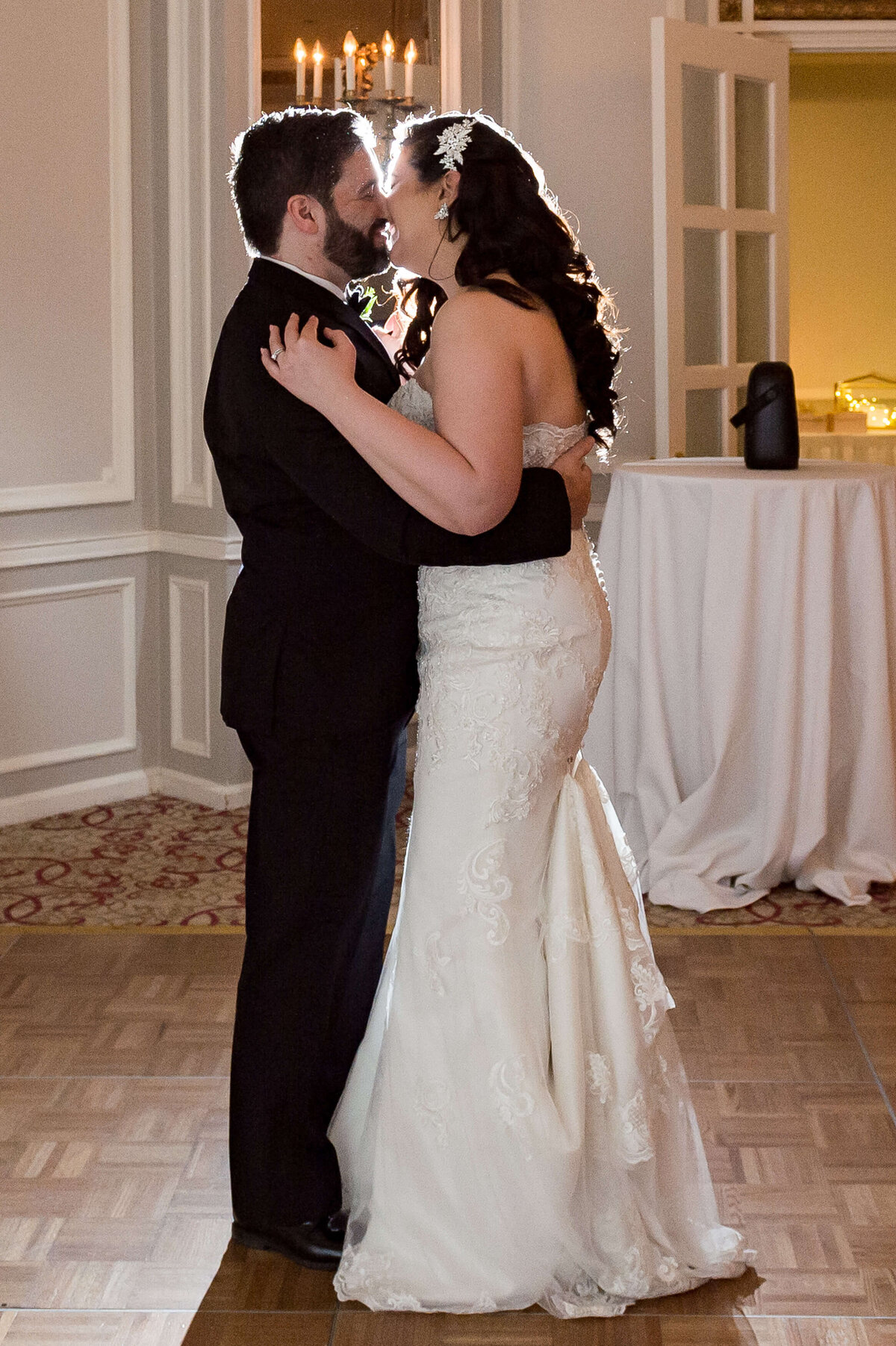 a bride and groom smile and kiss during their first dance indoors at the Chateau Laurier hotel.  Captured by Ottawa wedding photographer JEMMAN Photography