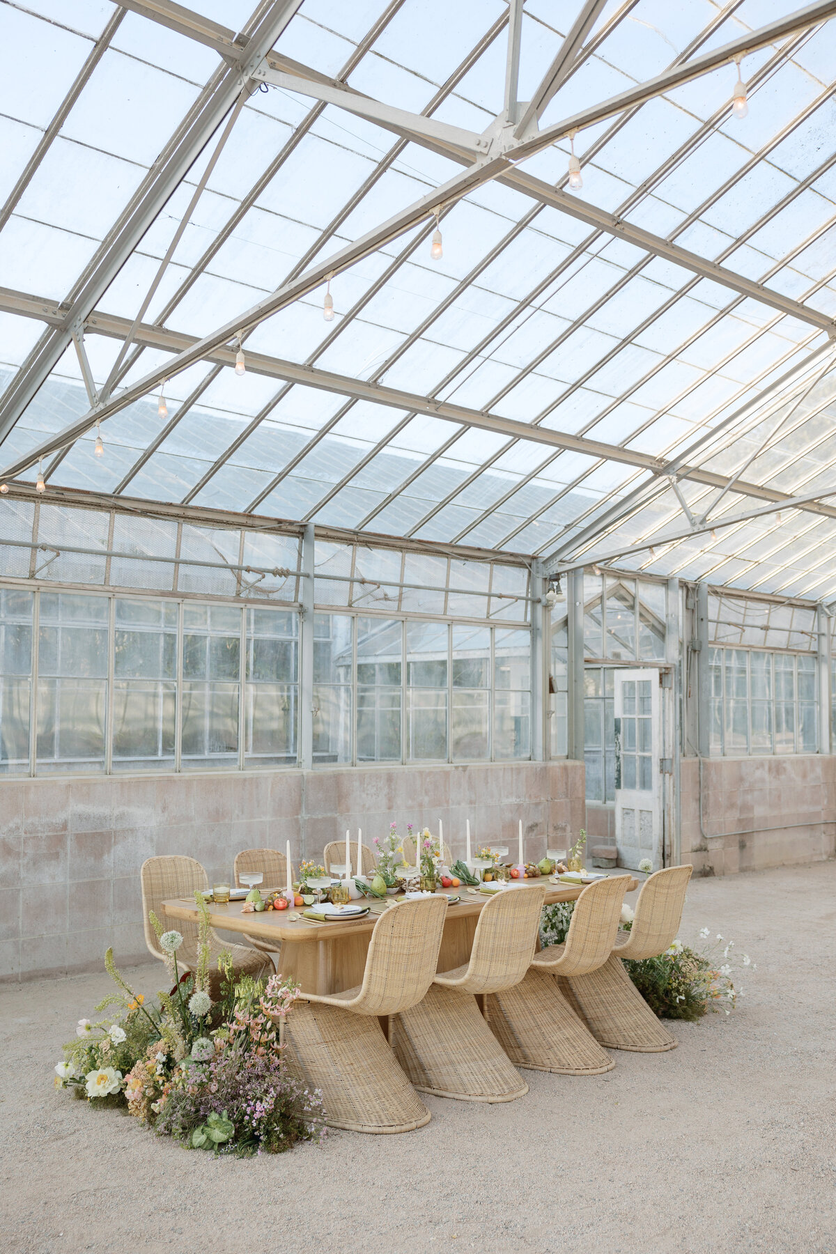 Reception details inside the greenhouse venue at Dos Pueblos Orchid Farm in La Jolla California, featuring lush floral arrangements and elegant decor.