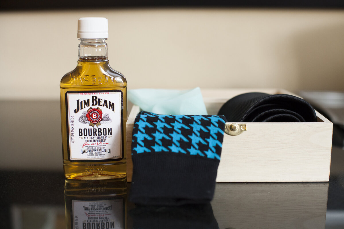 Socks and a small nip of Jim Beam sitting next to each other 