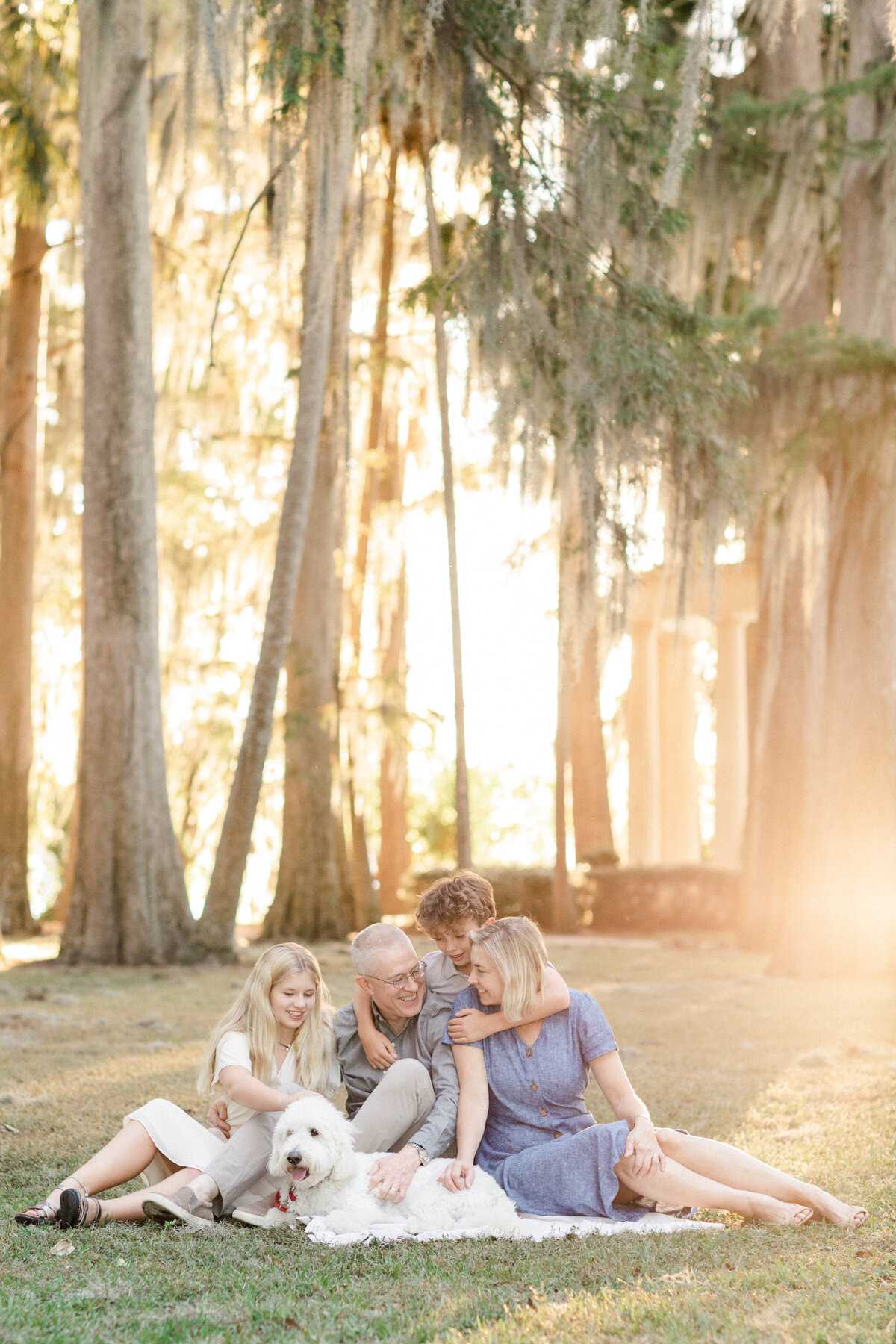 family with their do drenched in sunlight by Orlando family photographer