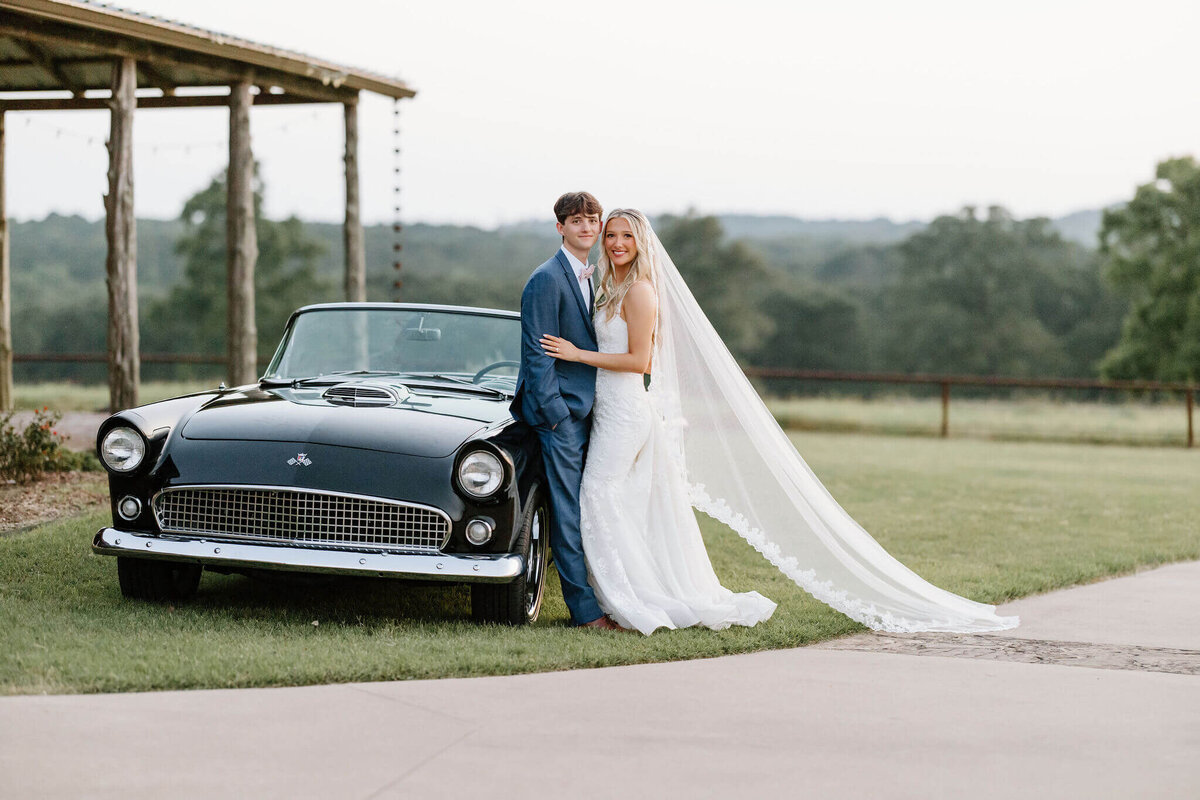 bride and groom portraits with vintage car on wedding day at Texas wedding venue