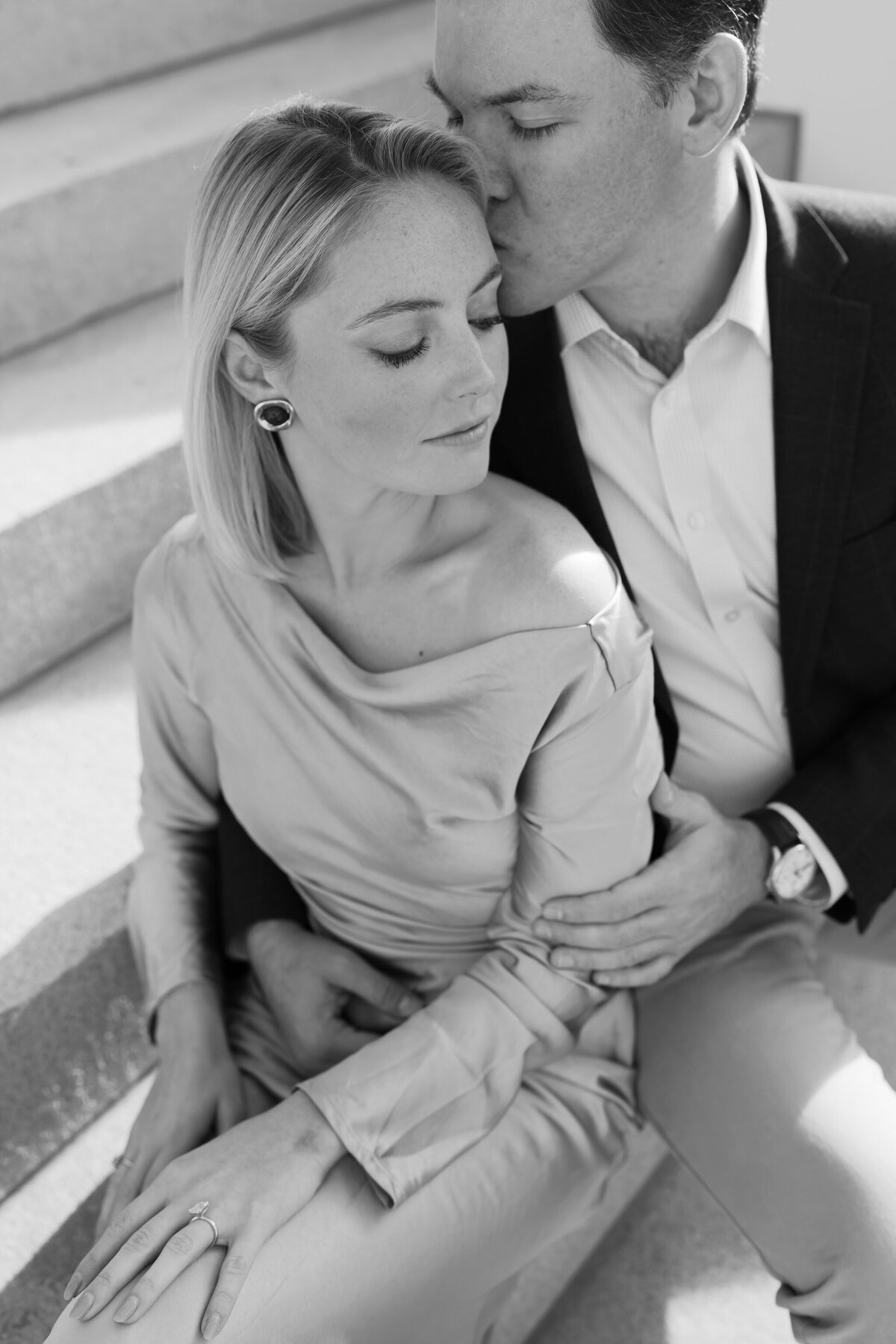 Richmond Engagement Photos | black and white closeup image of couple sharing an intimate cuddle on the white stairs of the Virginia Capitol Building