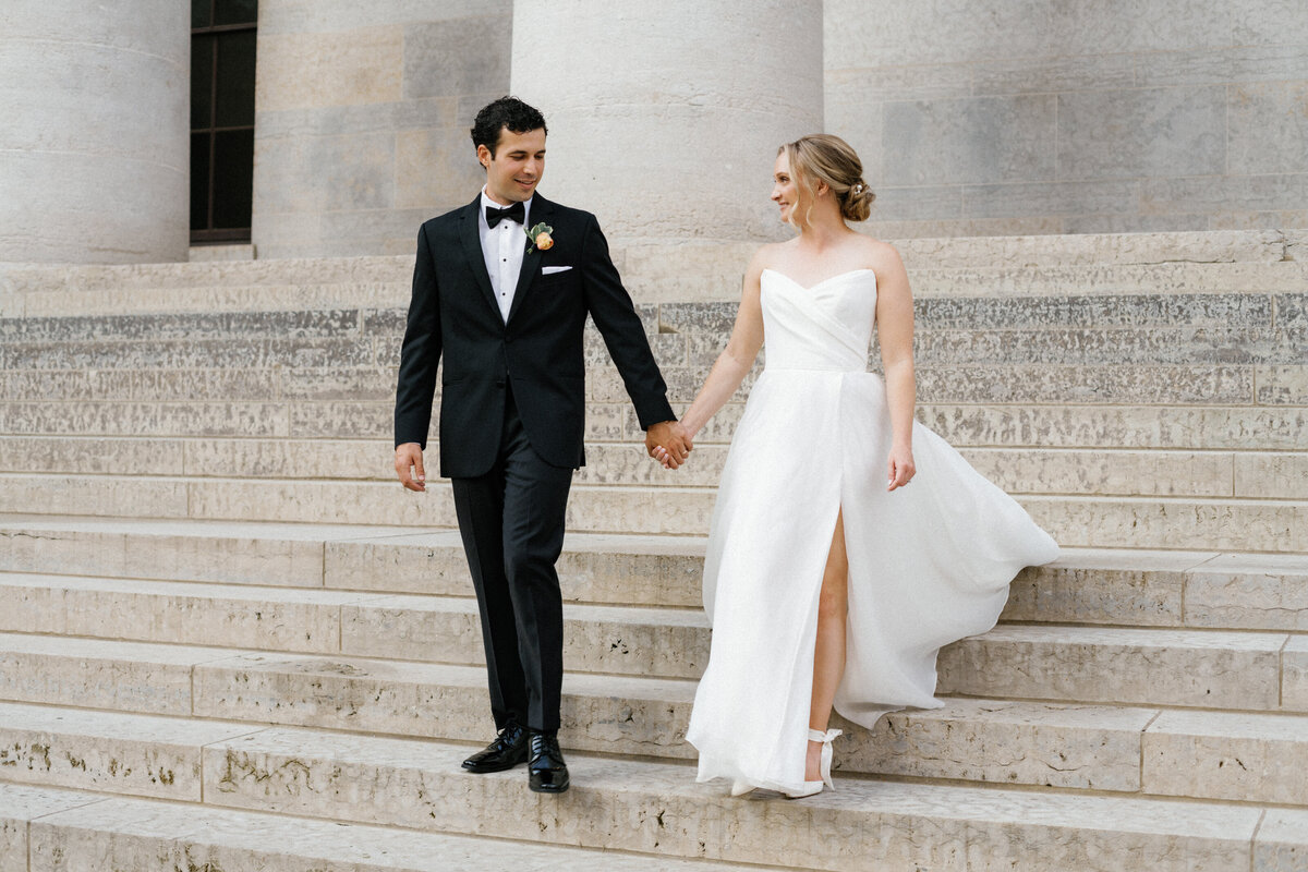 bride and groom walking hand in hand  down the stairs taken by Mansfield Wedding Photographer, Annie Trammel