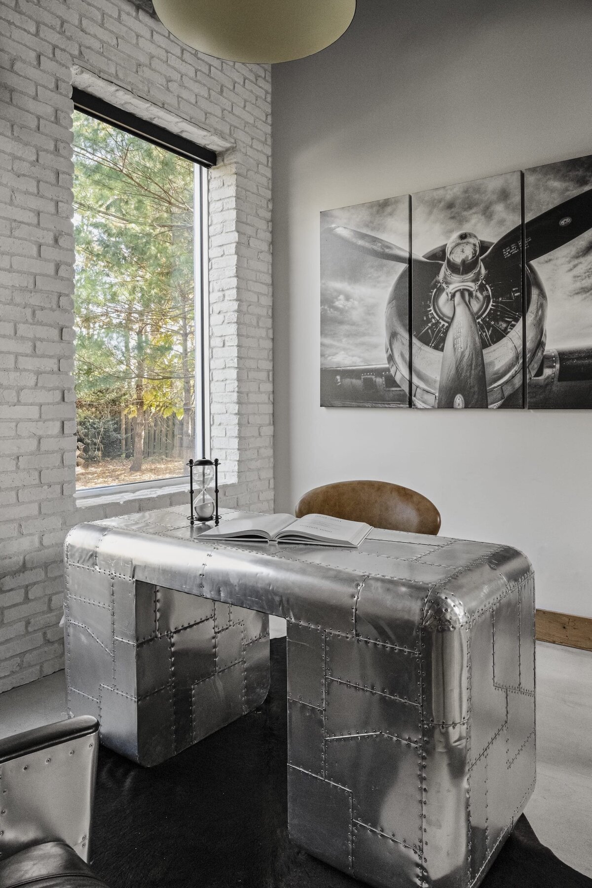 candra lynn interiors old bridge project metal office desk with leather chair and large black and white artpiece on wall