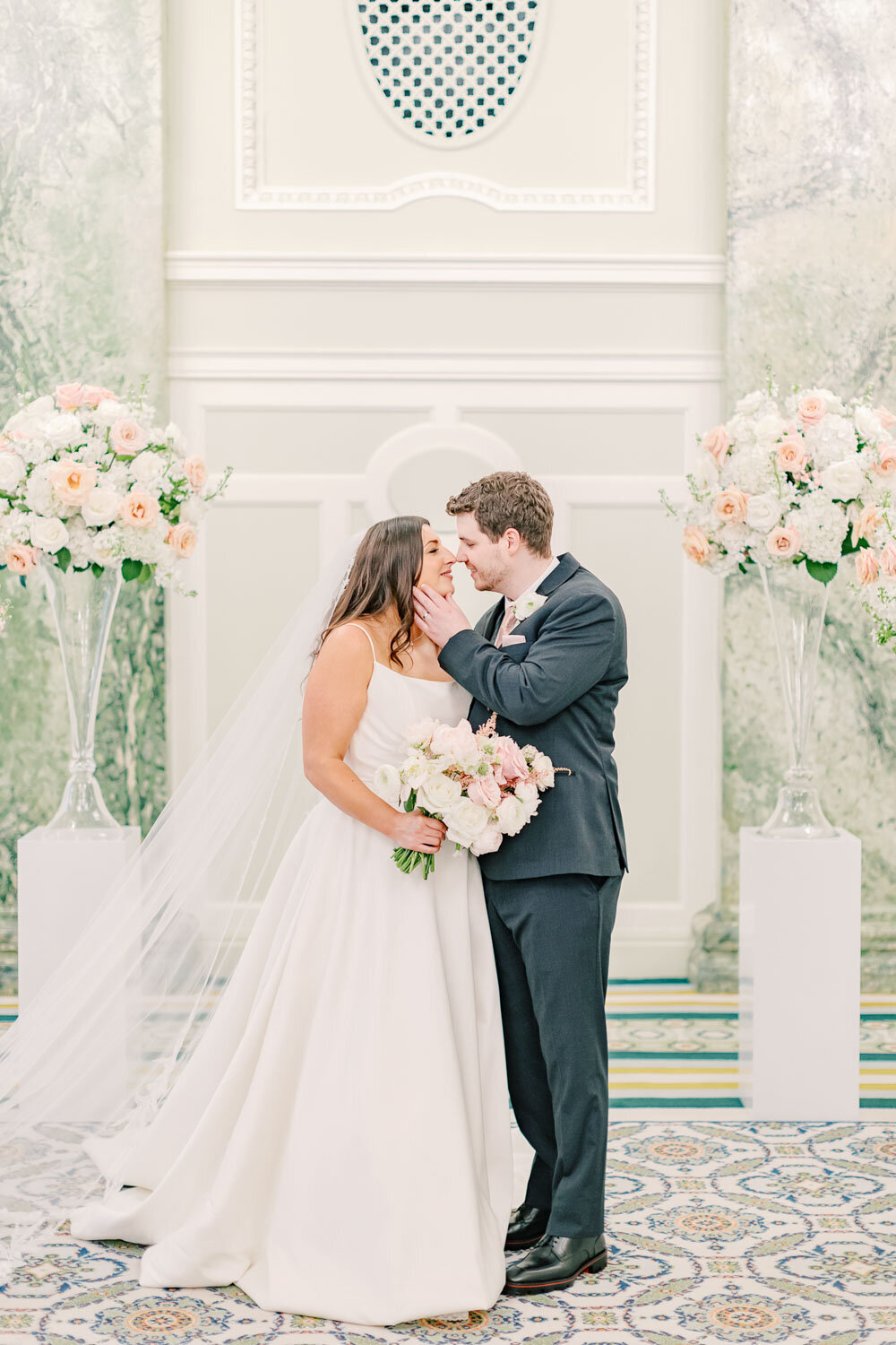 Bride and groom kiss at floral altar