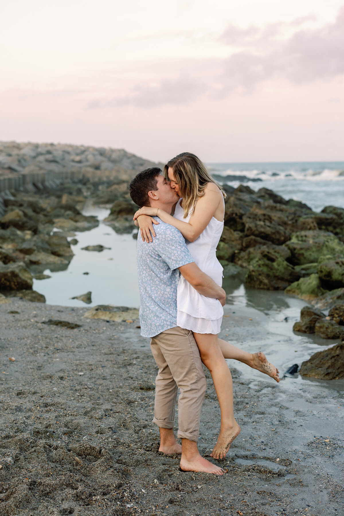 Engaged couple sharing a kiss on Wrightsville Beach