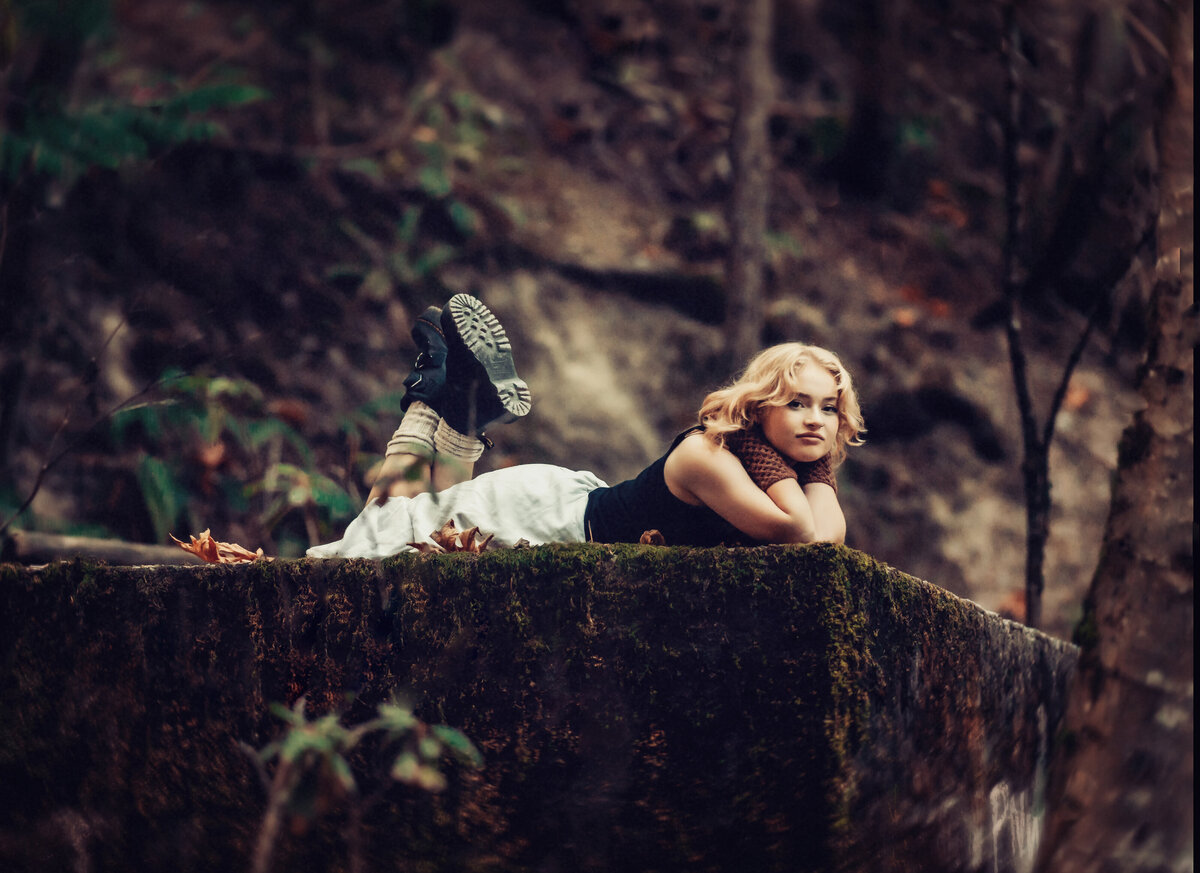 Girl on ledge in forest