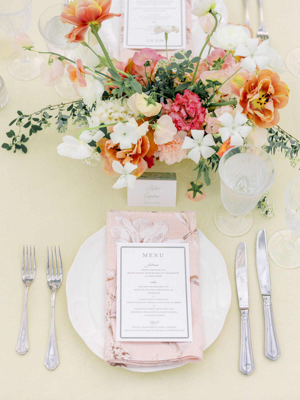 Dinner setting taken from above with plate, serving ware, glass ware, and flower centerpiece