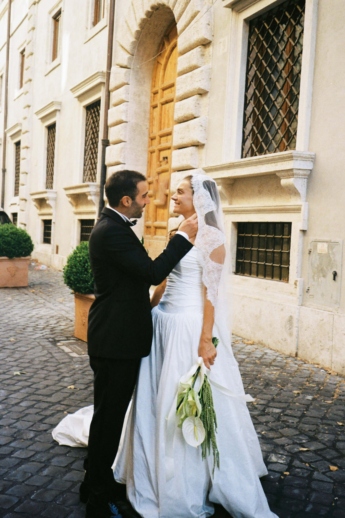 Bride holding bouquet while looking at groom with soft smile

