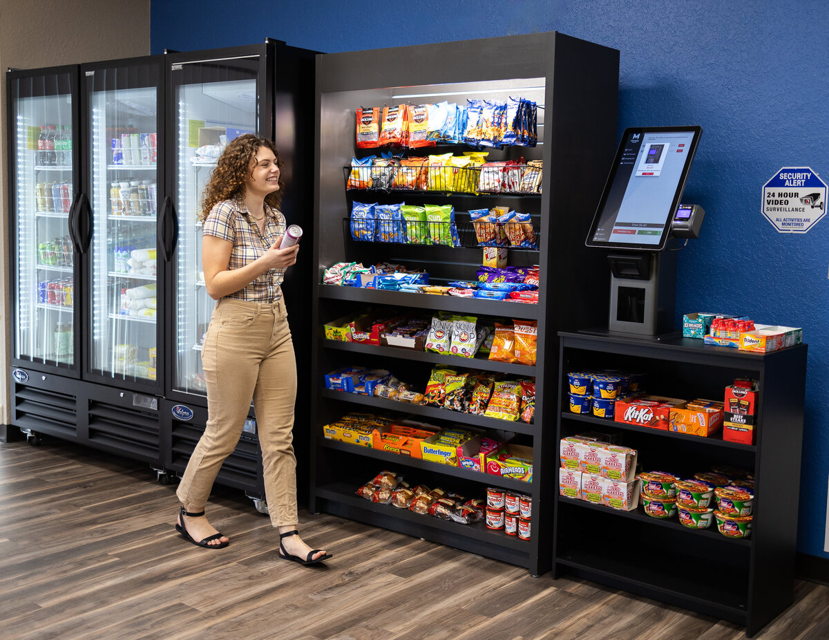 Employee gets a snack in the breakroom out of a vending machine.