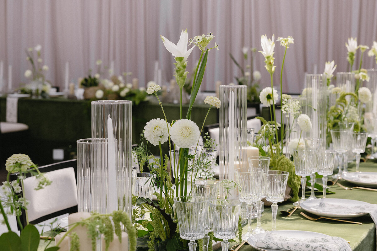 Modern centrepieces of white flowers and exotic greenery adorn a table at a Montreal wedding reception.