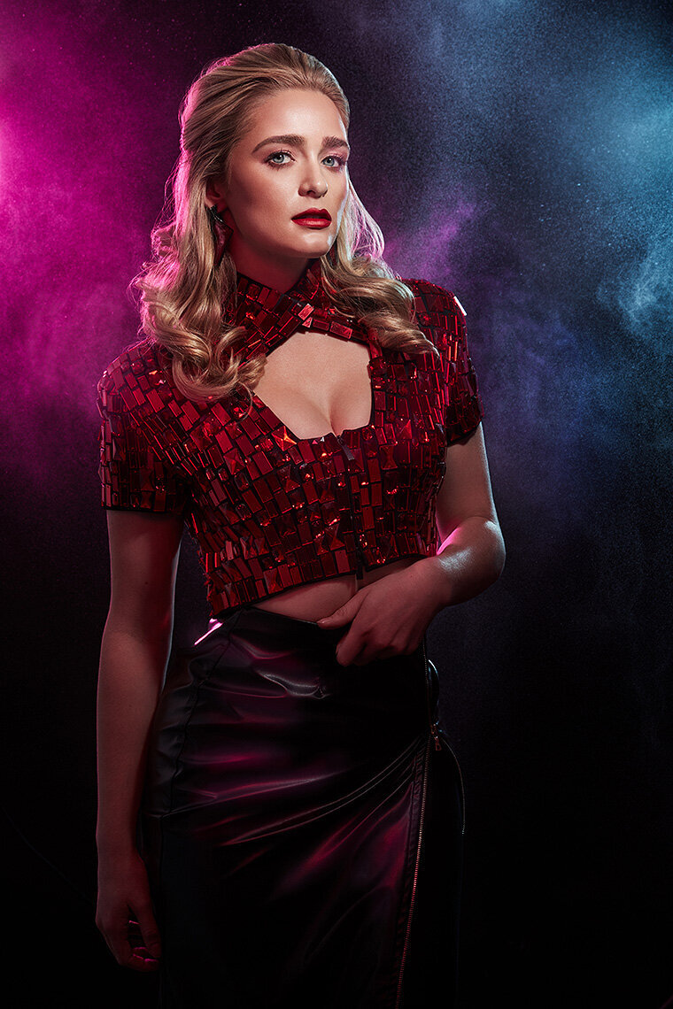Vibrant portrait of Greer Grammer in a red floral outfit with bold lighting, photographed by Ylva Erevall.