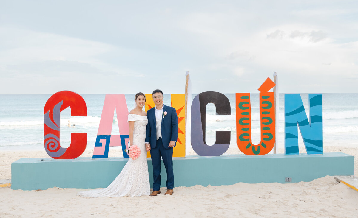 a bride and groom cheer in Cancun