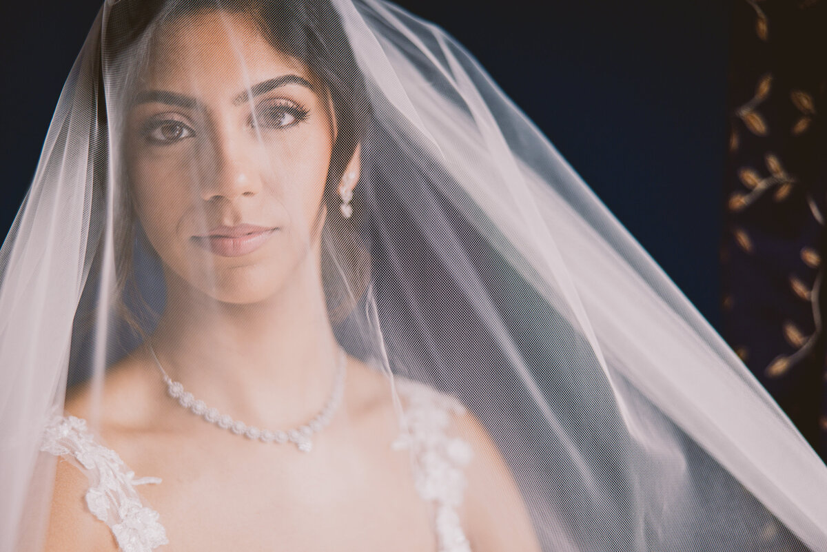 A closeup of an indian christian bride during her bridal prep on the wedding day with the veil over her head 