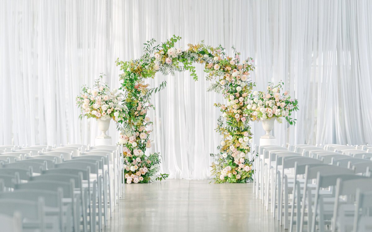 An arch of flowers and greenery at a wedding ceremony at the Science Centre.