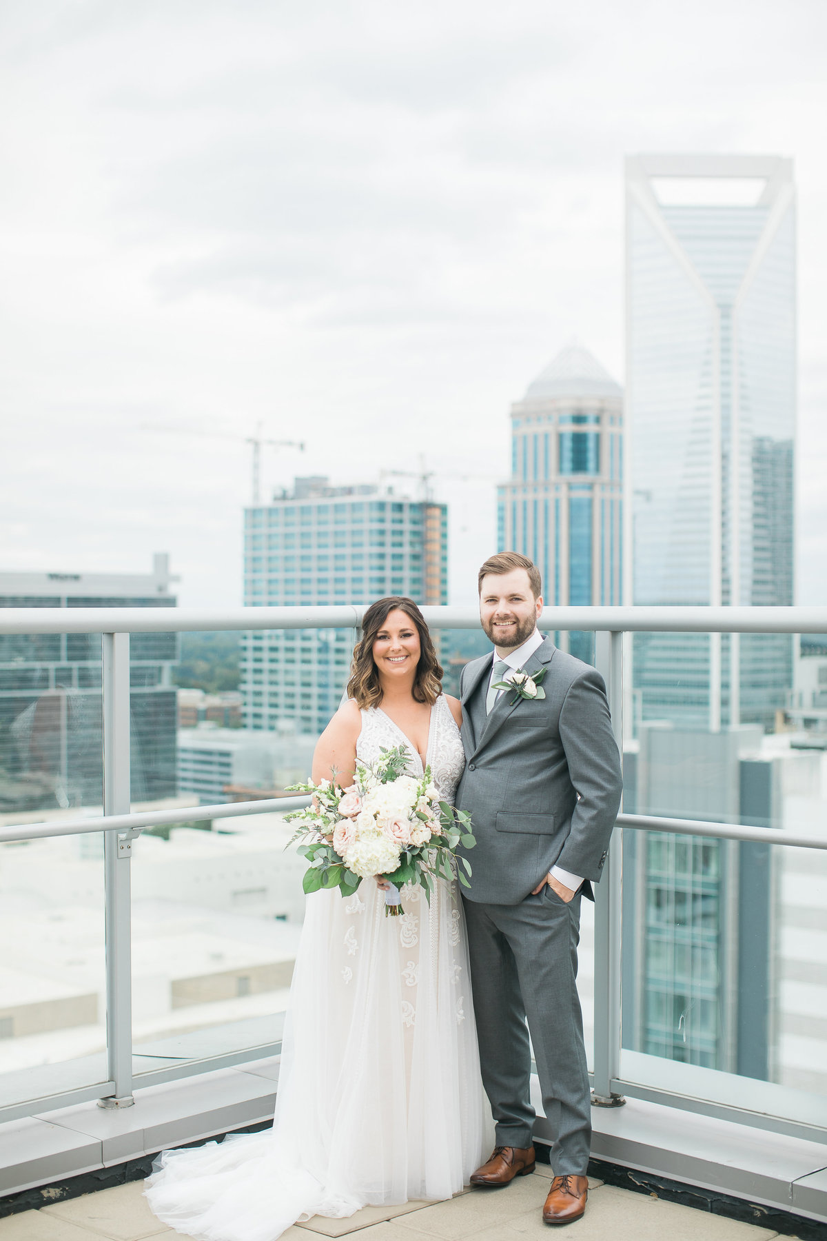 Wedding Photographer, couple standing together on top of a building