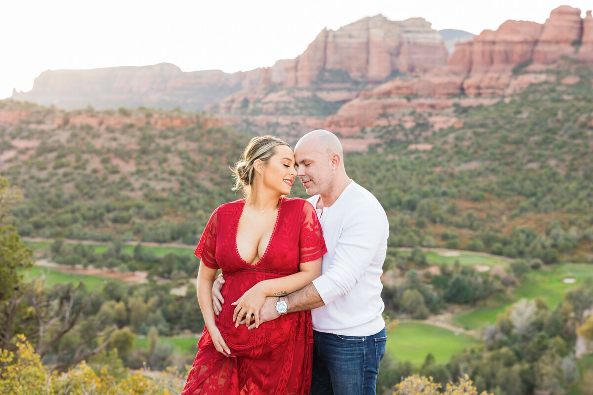 mom and dad to be posing for maternity photo in Sedona Arizona