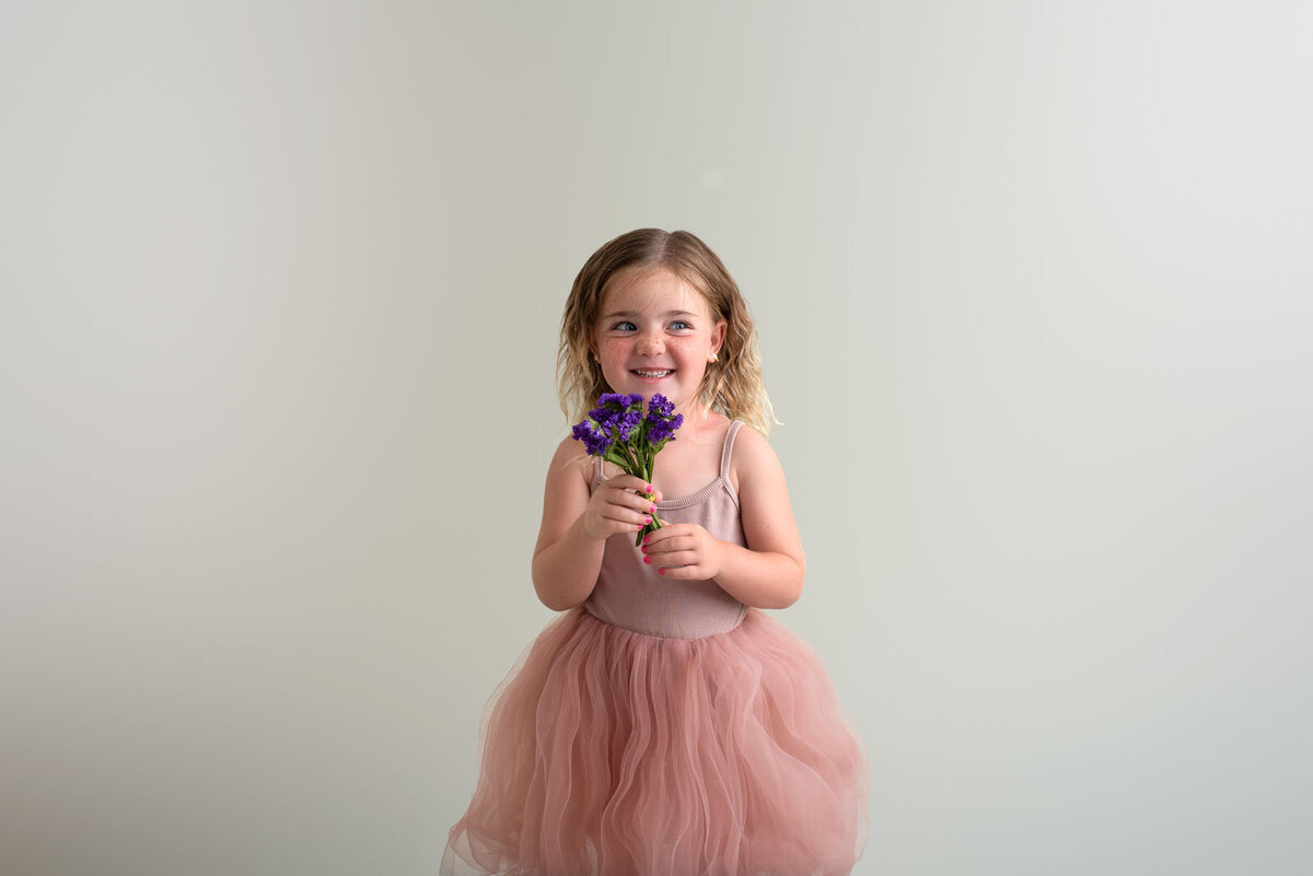 girl smelling flowers at st. louis family photography session