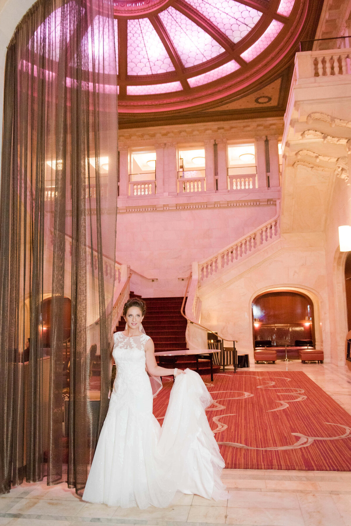 bride taking a beautiful wedding day photo in the lobby of the renaissance pittsburgh