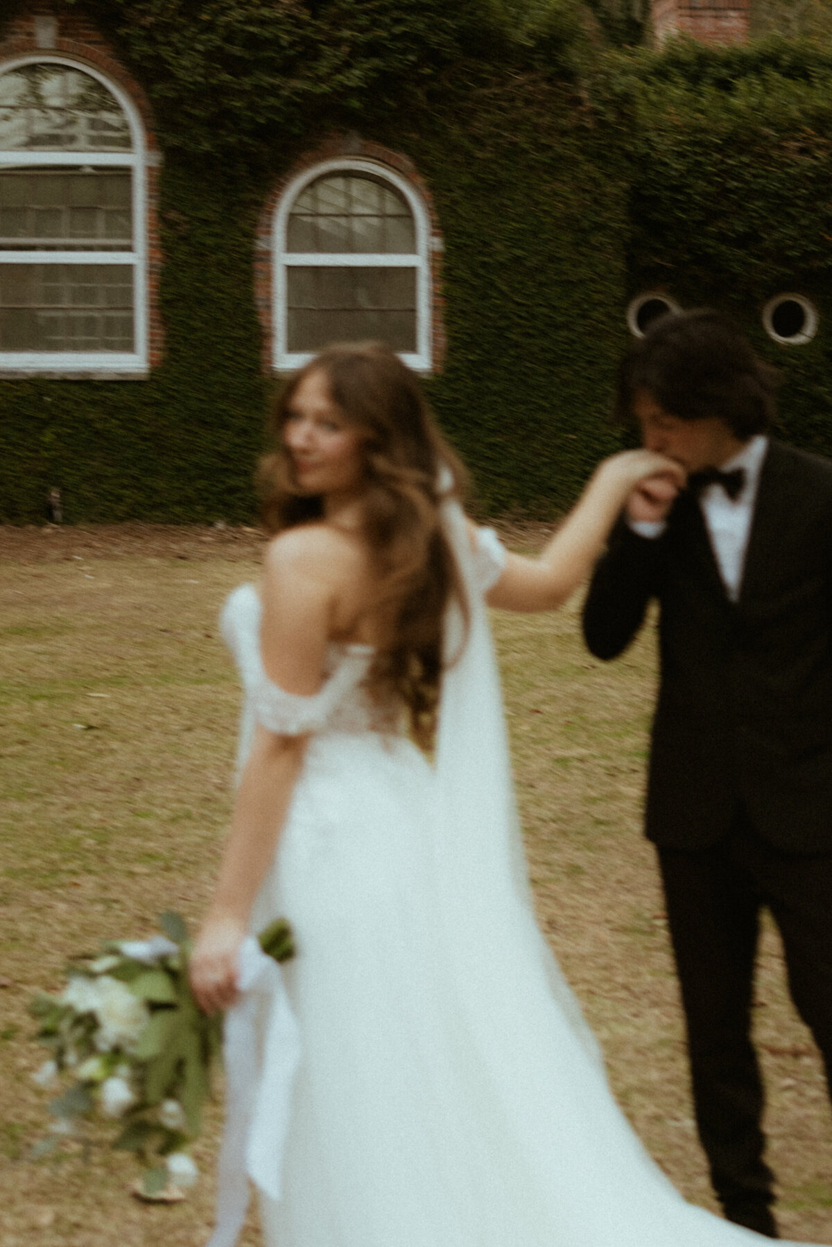 groom kissing bride's hand