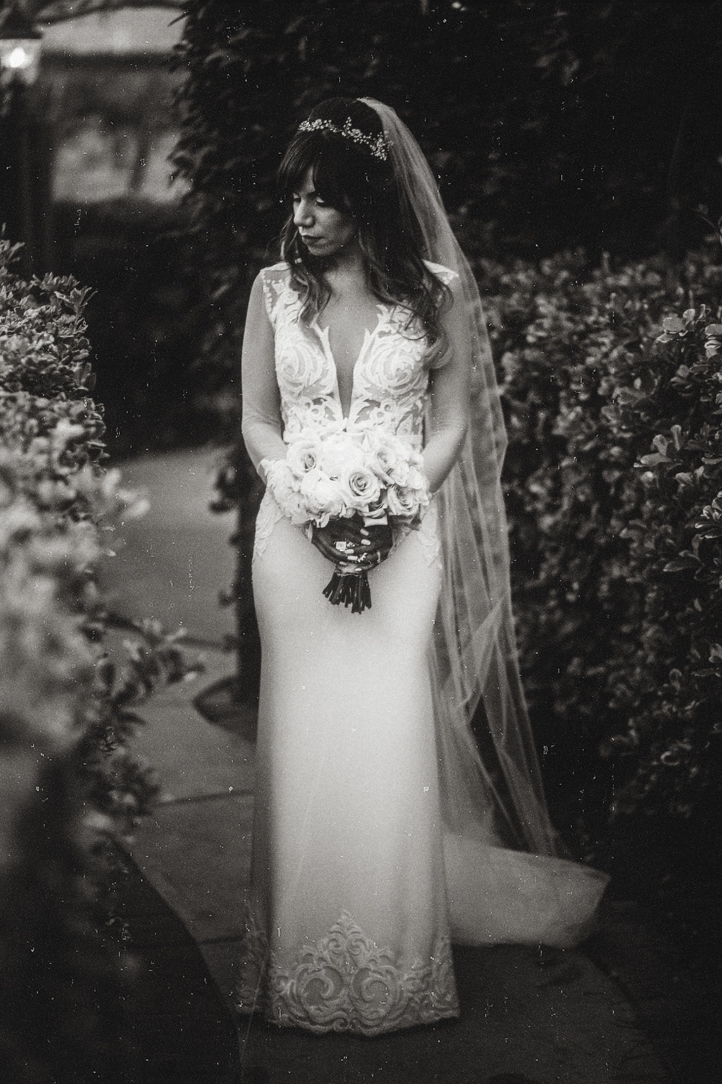 Wedding Photograph Of Bride Standing While Carrying a Bouquet in The Garden Black And White Los Angeles