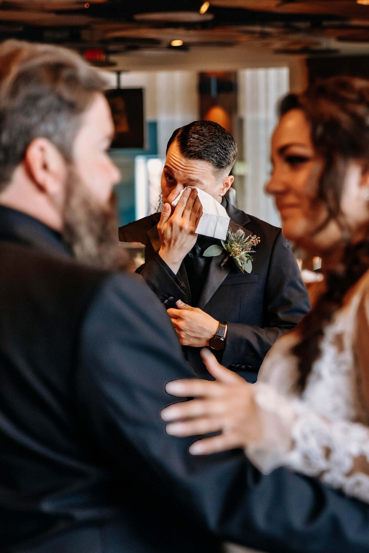 Shannon Lee, from Love Like Wild Photography, captures an emotional guest wiping tears as he watches the couple share a moment.