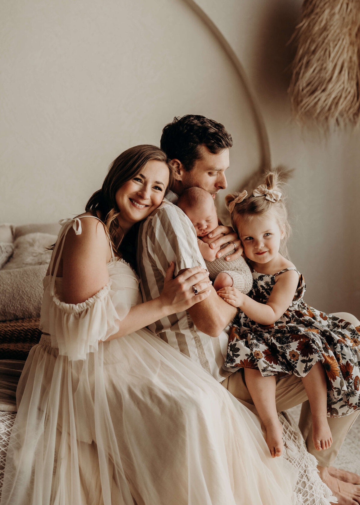 adorable family of four cuddles close to each other during newborn studio session in parker colorado