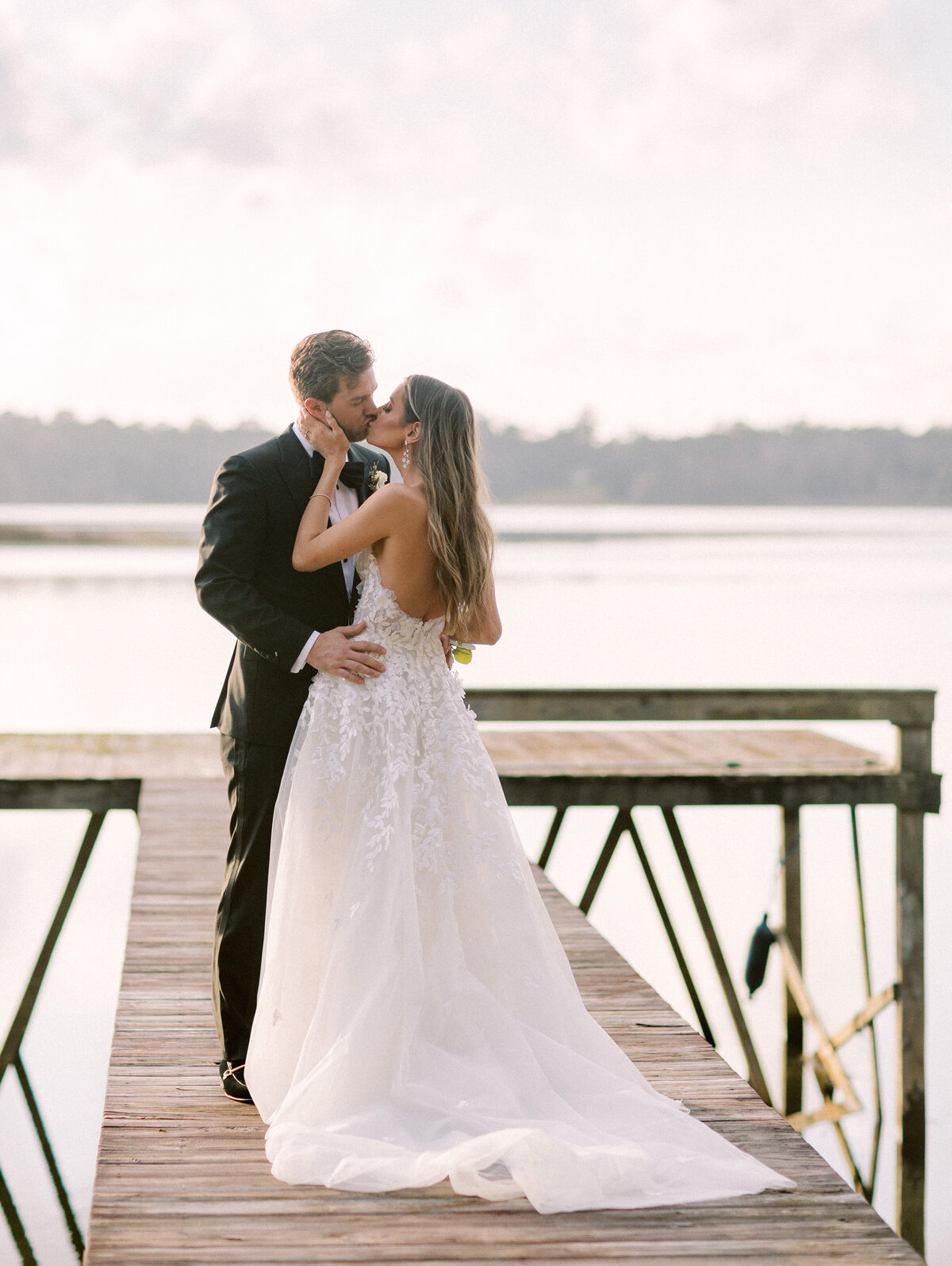 Bride and groom kiss on a dock
