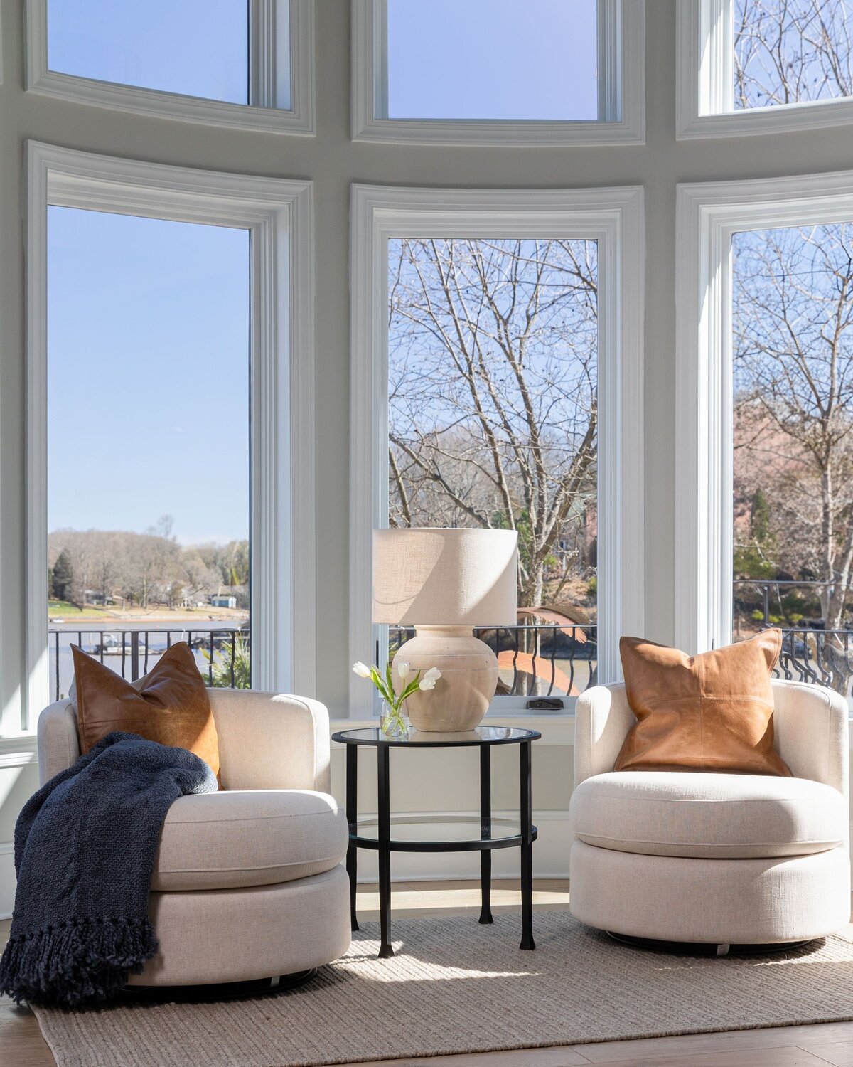 bright sitting area with boucle chairs and leather pillows