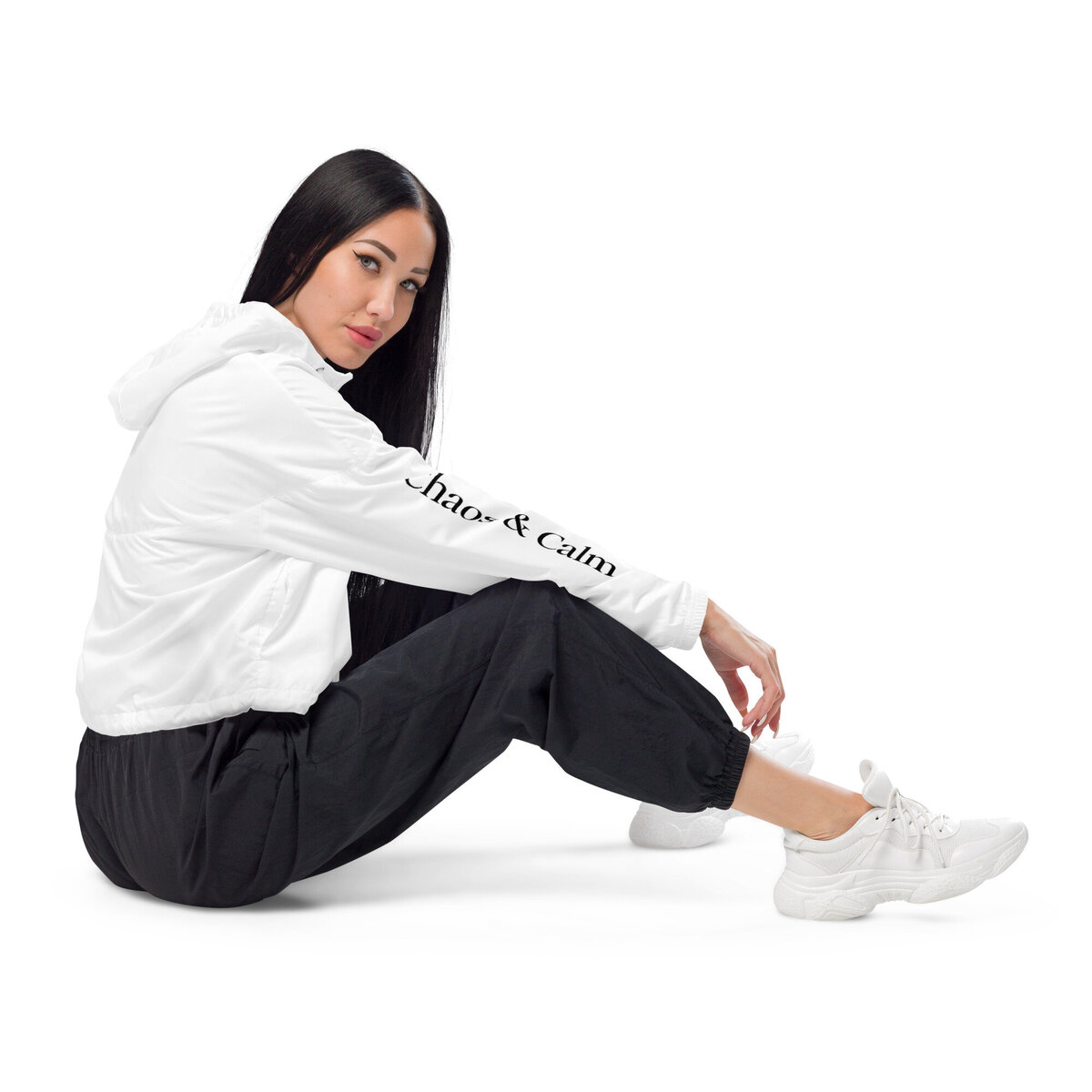 Seated woman wears the Chaos & Calm black and white cropped windbreaker I Merch Shoppe I Chaos  & Calm