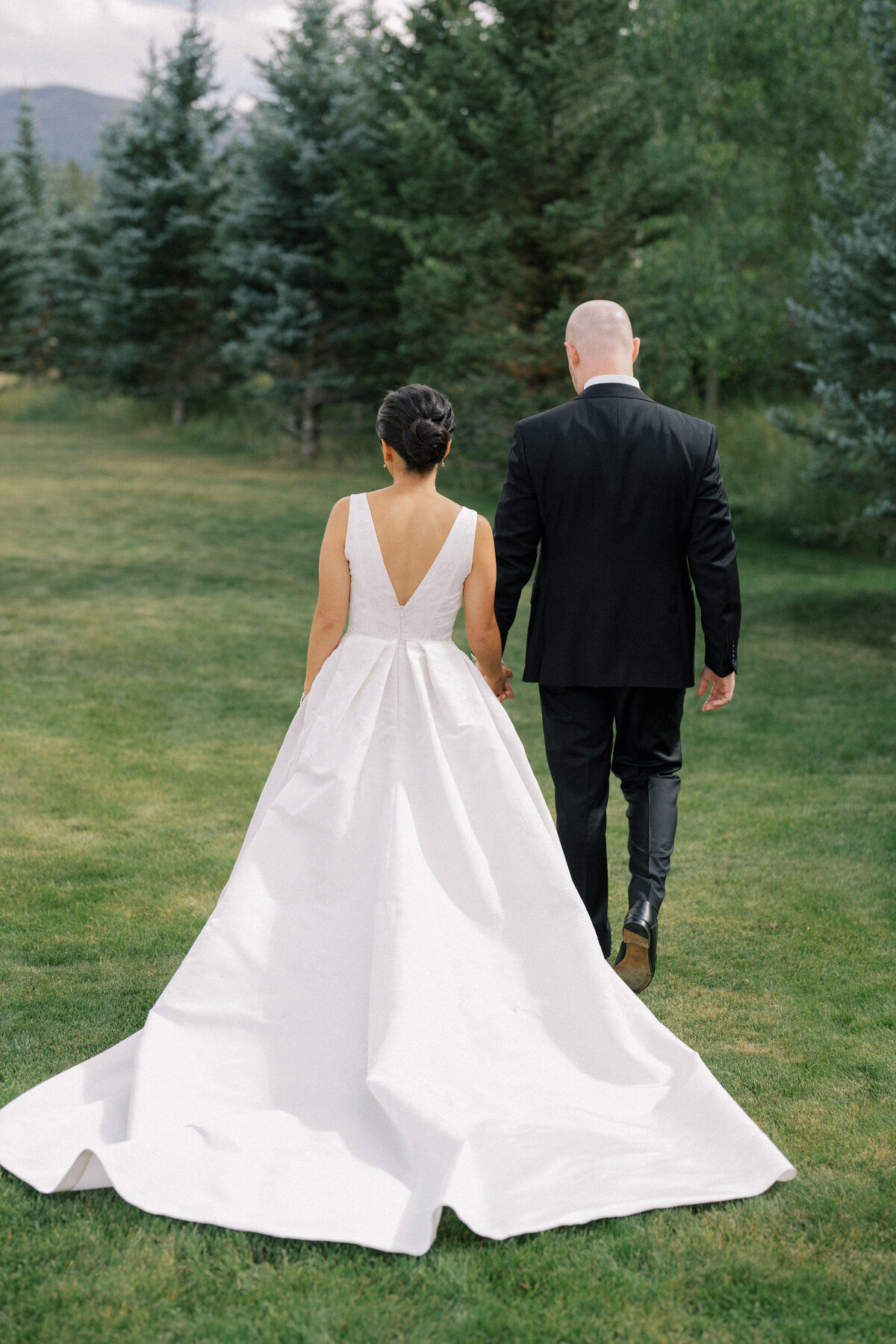 Couple walking among the trees at Montana wedding