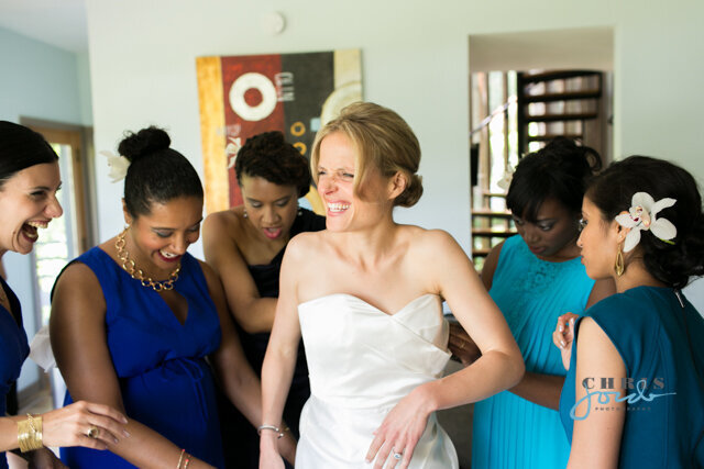 Bride and bridesmaids laugh  as they prepare for the wedding