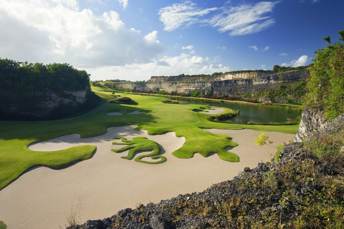 The iconic Green Monkey Golf Course in Barbados, featuring a signature sand trap design shaped like a green monkey, set against a stunning limestone quarry backdrop.