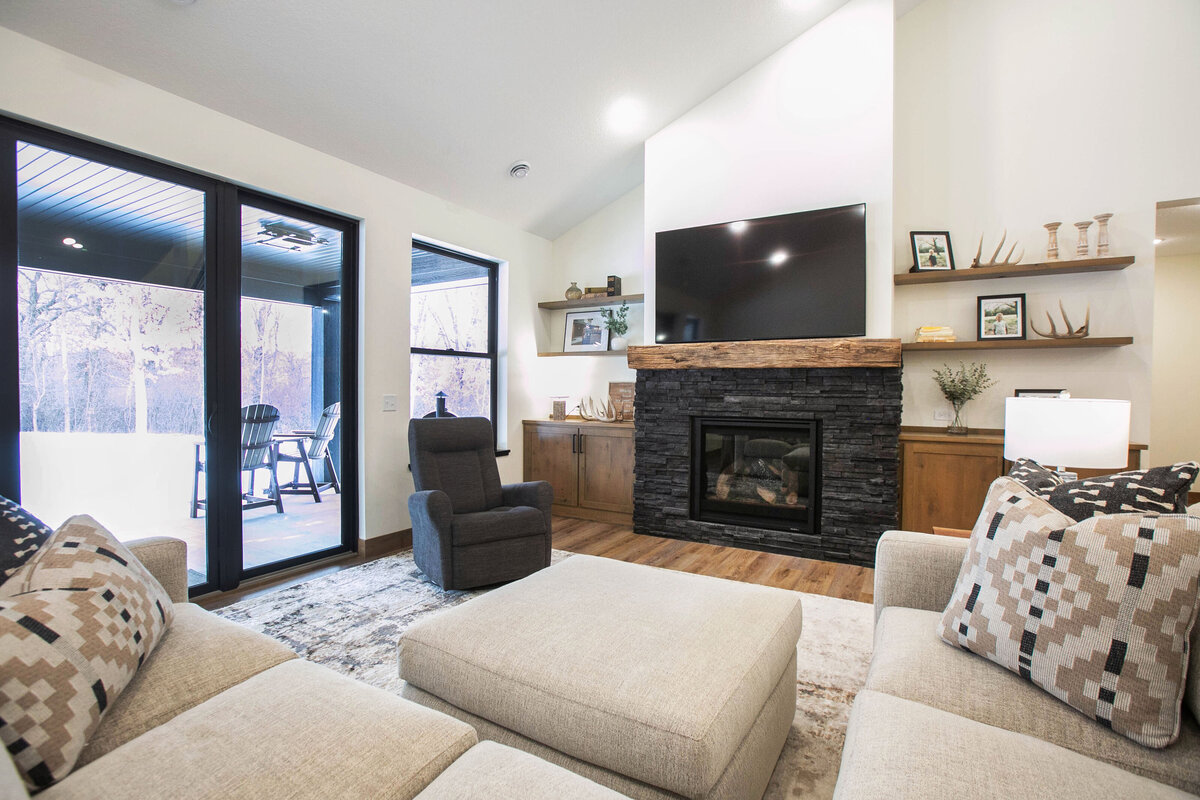 Cozy living room in Elk River custom home with fireplace, built-ins, and large windows