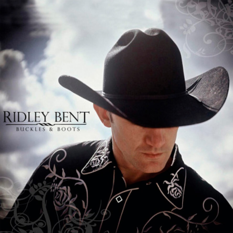 Country Music Album Cover Title Buckles and Boots Artist Ridley Bent closeup portrait eyes shielded beneath big black cowboy hat wearing black collared shirt with white embroidery shirt against puffy clouds in sky