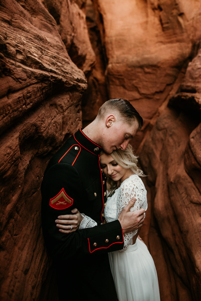 husband and wife hugging in a red rock canyon